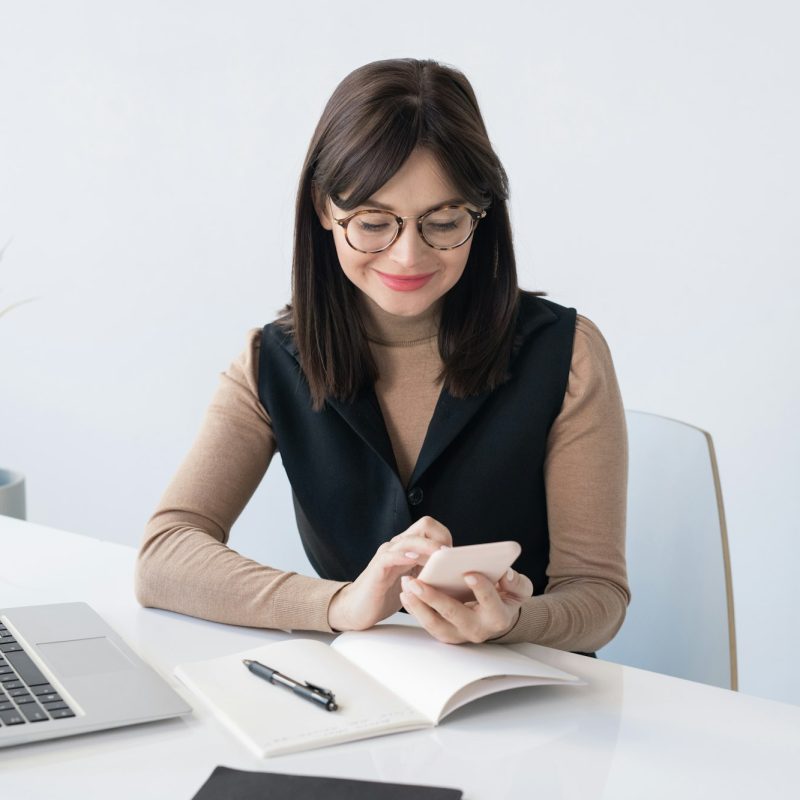 young-teacher-or-businesswoman-with-smartphone-over-open-copybook-1.jpg